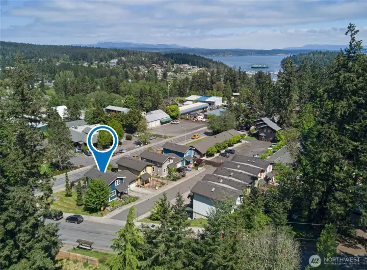 A location pin marks this special address within the heart of Friday Harbor, with the ferry dock, marina, and shimmering Puget Sound waters visible just beyond the tree line. Walk to the library, schools, shops, and restaurants while coming home to your own private, low-maintenance island retreat.