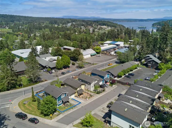 The highlighted footprint of this corner-lot craftsman reveals a well-proportioned property with generous outdoor space, an attached garage, and a fenced private yard — standout features for an in-town Friday Harbor address. Bold blue siding and curated landscaping give the home unmistakable curb presence.