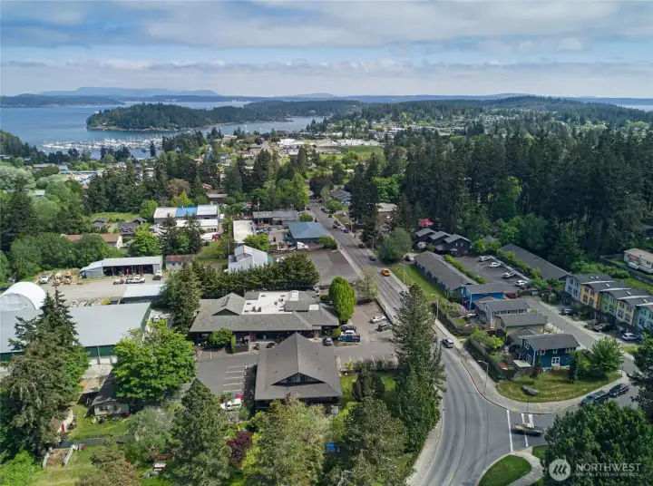 Sweeping aerial perspective reveals the property's coveted in-town position on San Juan Island, with Friday Harbor's iconic marina, Salish Sea waters, and forested islands stretching to the horizon — walkable to everything, yet tucked into a peaceful residential enclave.