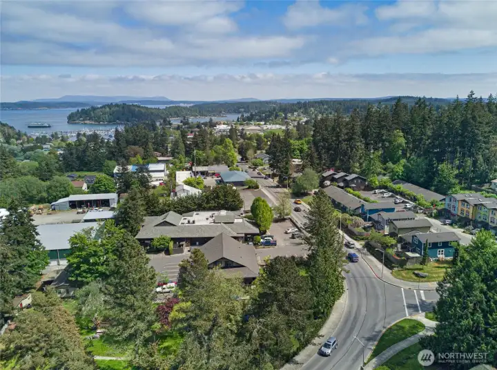 Panoramic aerial reveals the breathtaking San Juan Islands backdrop that defines life on the island — sparkling water, forested shores, and open sky visible from this centrally located, walkable neighborhood.