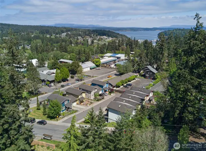 Sweeping aerial views reveal the home's exceptional Friday Harbor location — just blocks from downtown, with sparkling San Juan Channel waters and the distant Cascade peaks visible on the horizon. This is island living at its most connected, where everything you need is steps away yet nature surrounds you.