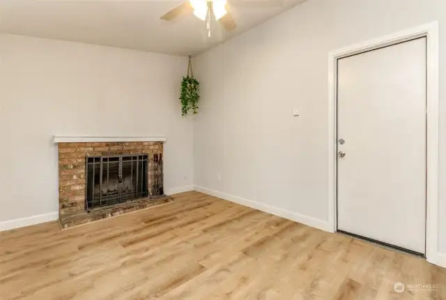 The family room has a vaulted ceiling and there is an overhead light fixture fan and a fireplace