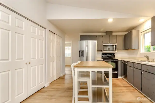 Full sized washer and dryer in laundry closet on left