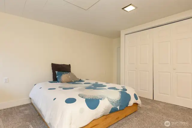 The larger of two lower floor bedrooms, with custom closet, radiant ceiling heat, and extra storage.