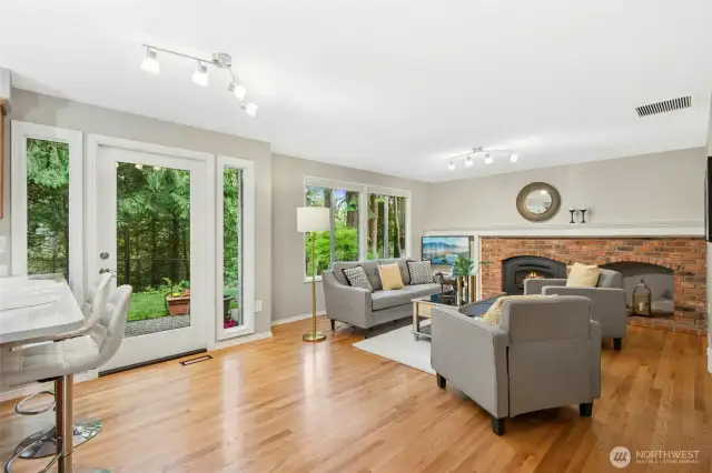 Another angle showing the wall of windows to allow for lots of natural light. Gas fireplace with a remote and more gorgeous hardwood floors.