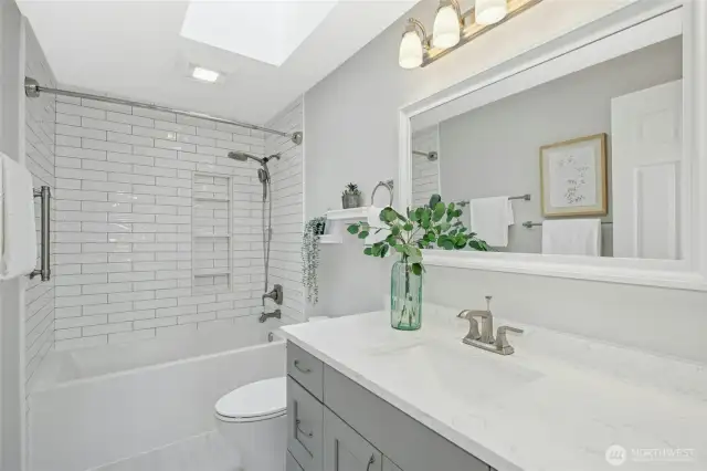 Updated guest bath with a light flooding skylight.