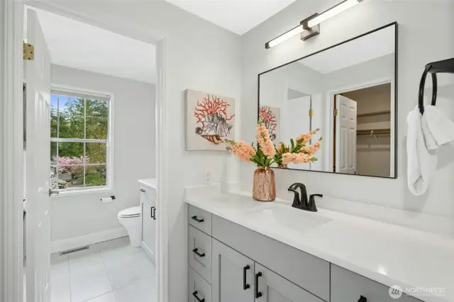 beautiful spa-like remodeled bath room offering tile floors and a walk-in closet.