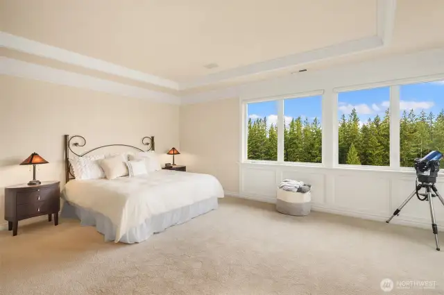 The spacious bedchamber is accented by wainscoting & crown molding.