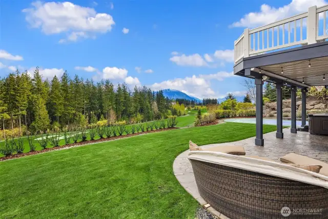 Expansive lawn with in-ground sprinklers backs to the 8th fairway.