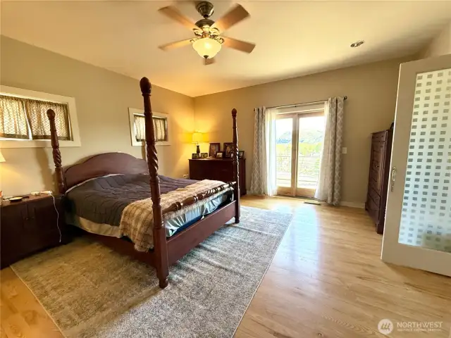 Primary Bedroom With Doors Out to the Deck Which Overlooks the River and Golf Course