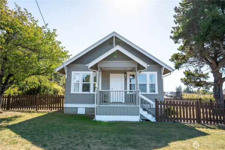 Straight on view of the home - bedroom to the left, small porch leads into the living room, livving room window to the right .  Front steps go to a great fenced side yard.