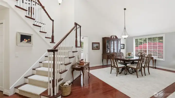 The dining room can easily accommodate 10+ guests.  Tall, vaulted ceilings match the living room and the staircase as they rise to the 2nd floor.