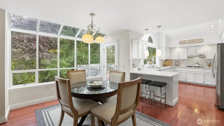 The eating nook just steps from the kitchen is very spacious with a large glass window wall. Wonderful natural light and peaceful views.