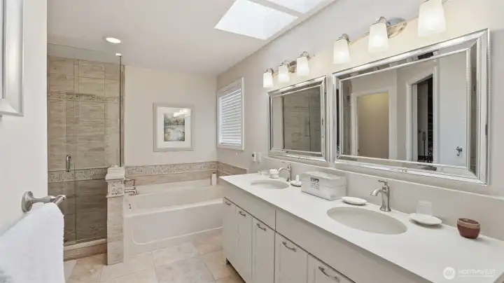 The primary bath is grand with stunning finish work and materials. Large heated tile floors, quartz counters and backsplash and cutom lighting.  A double sky light plus a professtionally designed walk-in closet.
