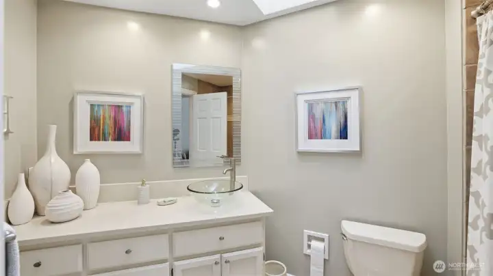 The upstairs full hall bath has been updated with quartz counters, tile floors plus skylight.