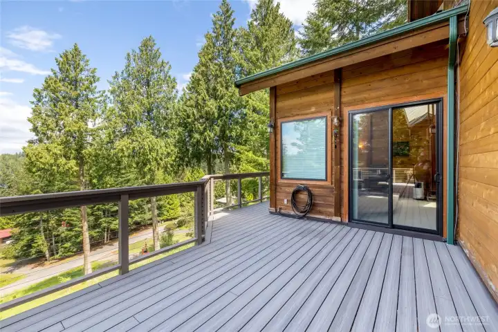 Private deck access from the primary suite, creating an effortless indoor-outdoor flow surrounded by mature trees