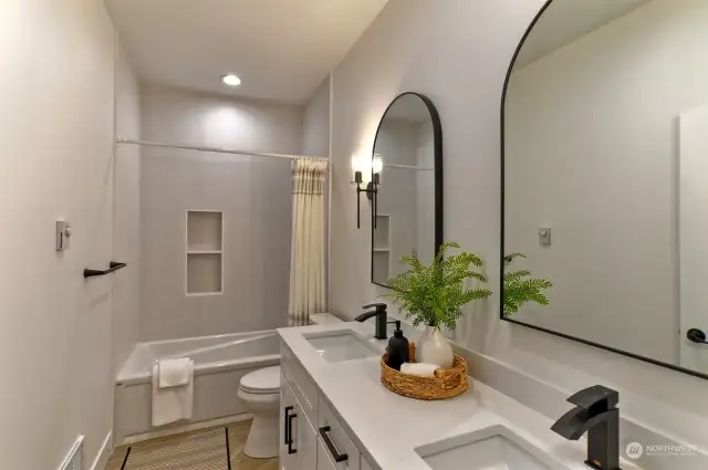 Spa like guest bath has dual undermount sinks and quartz countertops.