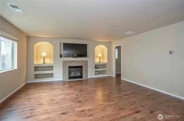 Unwind in the family room complete with stylish built-ins, charming niches, and rich laminate hardwood floors.
