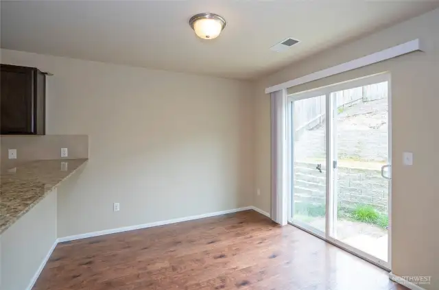 Another view of the dining area with convent sliding door leading to the private fenced, terraced backyard.