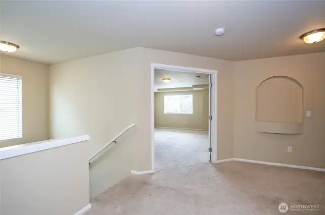 View from the top of the landing into the primary suite, highlighted by elegant double doors.