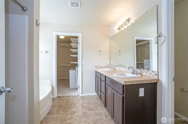 Expansive primary bathroom with dual vanities, soaking tub, and separate shower.