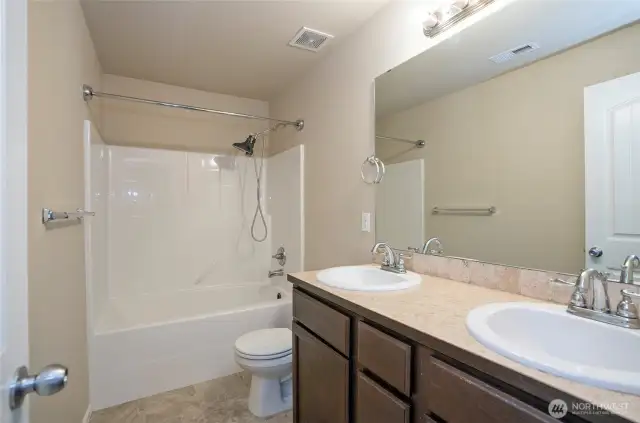 The upper-level full guest bath offers dual vanities—perfect for busy mornings.