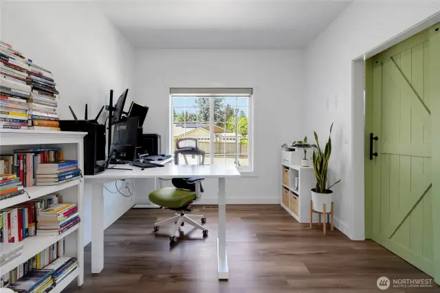 Bright and open office space with barn door for privacy.