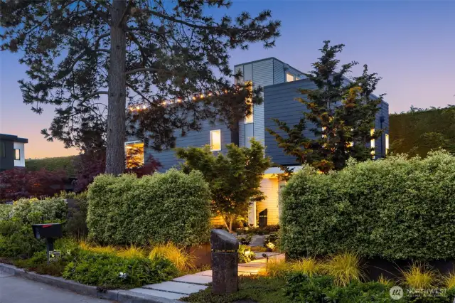 Professionally landscaped with pavers, fenced yard, and custom steel raised flower beds.