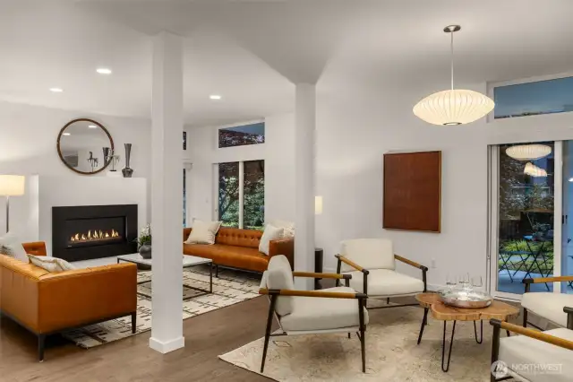 Open concept formal living room is warmed by a gas fireplace and boasts quality hardwood floors.
