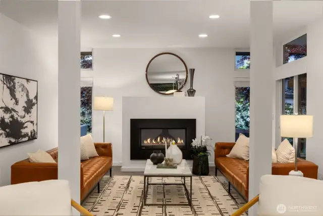 Open concept formal living room is warmed by a gas fireplace and boasts quality hardwood floors.