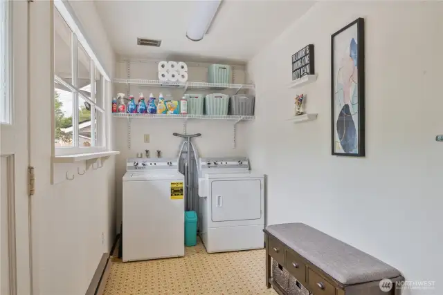 Spacious mud room/utility opens to the back yard
