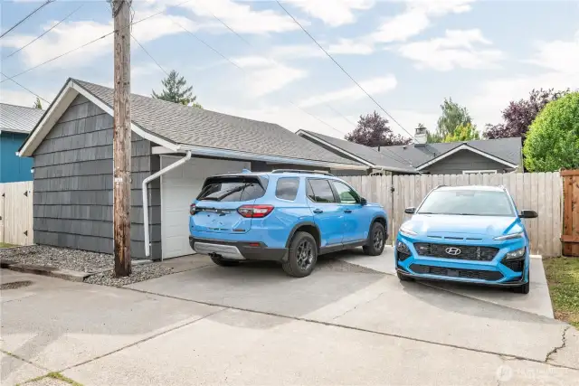 One car garage with storage room plus paved parking for two full size cars behind the fence