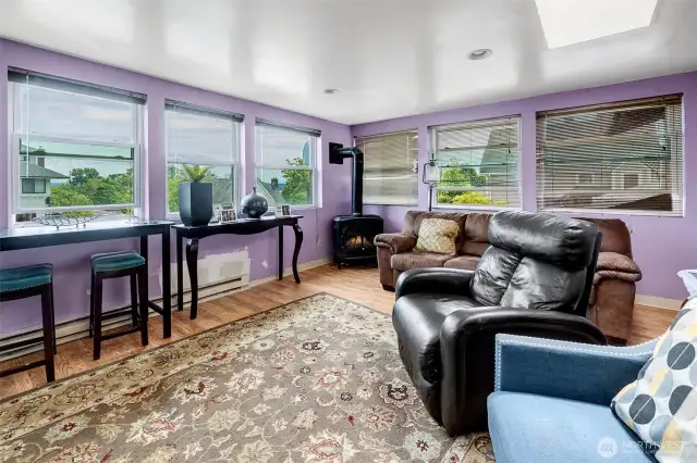 Upper level sunroom with pretty territorial views to the east. Skylights and window walls bring the outside in, fire up the free-standing stove and you have the perfect place for chasing away the gray days of Seattle winters. There is entry to the upper level deck from this room.
