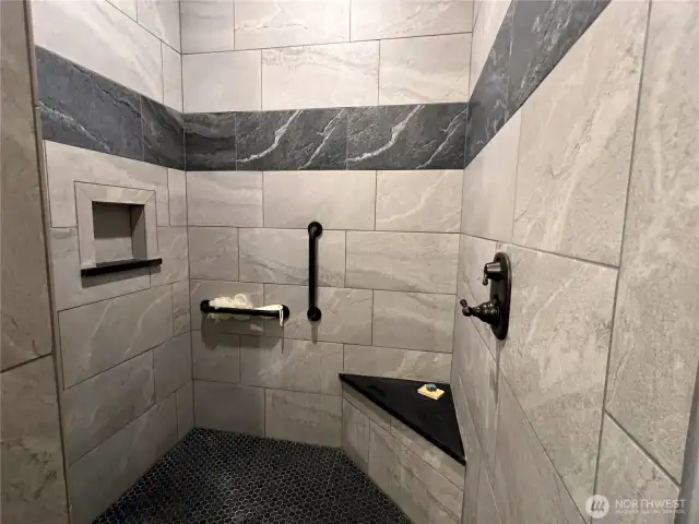 Luxury custom tile shower in primary bathroom.
