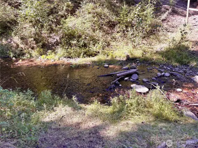 Cute sitting area near the creek for relaxation and reflection.