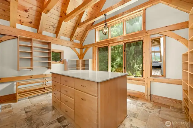 Walk in closet with quartz island & vaulted timber frame ceiling.