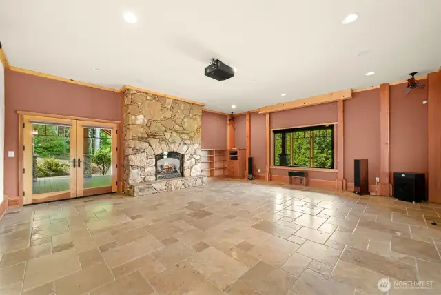 Lower level media room/bonus room with stone floor to ceiling fireplace
