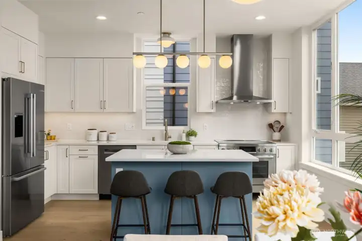 Stunning finishes from floor to ceiling. The blue island ties the white cabinetry together while matching the exterior of the home.