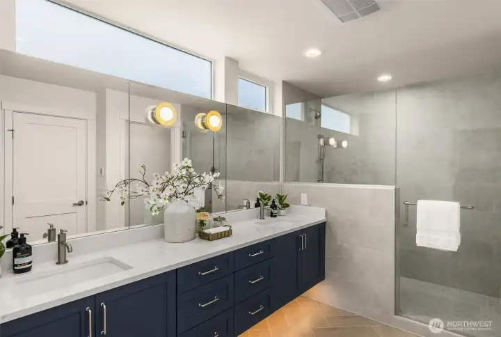 Toe-kick lighting, full vanity mirror, thick quartz countertops continue the luxury feel of the home.