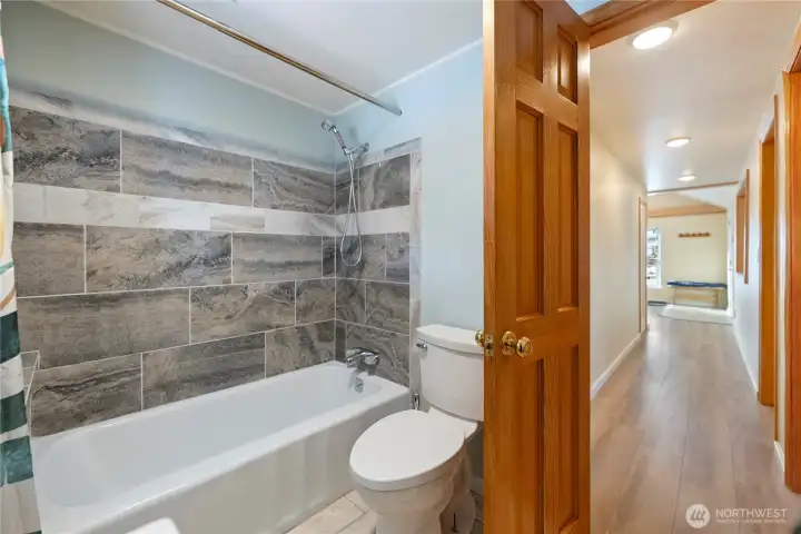 Downstairs full bathroom w/ tile floor and shower