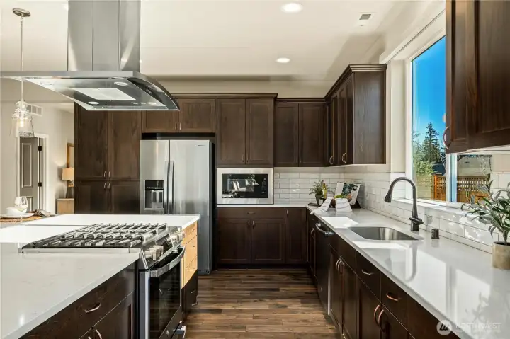 The gorgeous kitchen with a VIEW of Mt. Rainier boasts Quartz countertops, classic cabinetry w/ sleek hardware and top tier appliances. Undermount single sink & timeless backsplash.
