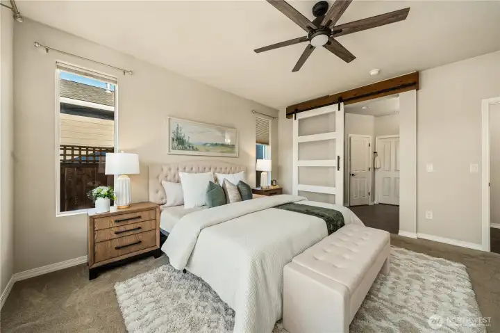 Primary bedroom with a fantastic custom barn door into the beautiful bathroom.  Custom window coverings throughout.