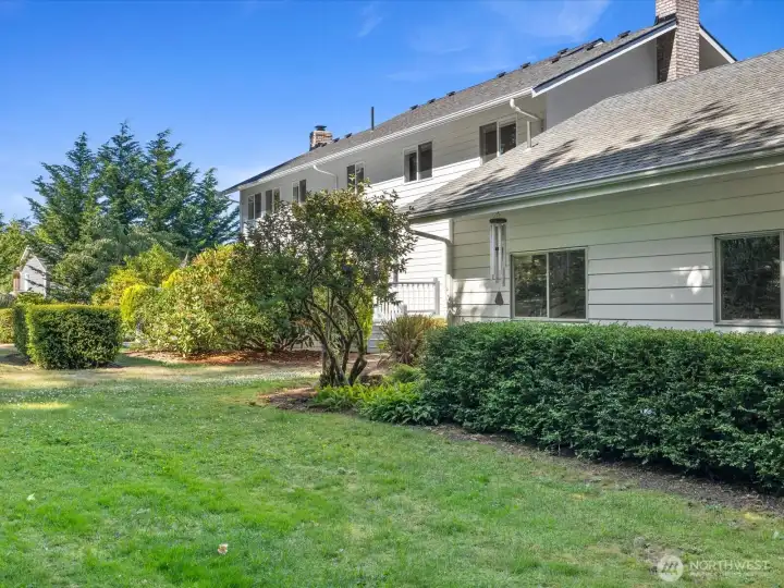 Beautiful sprawling yards create outstanding outdoor spaces, with    mature trees, many blooming flowers, & large wooded area.