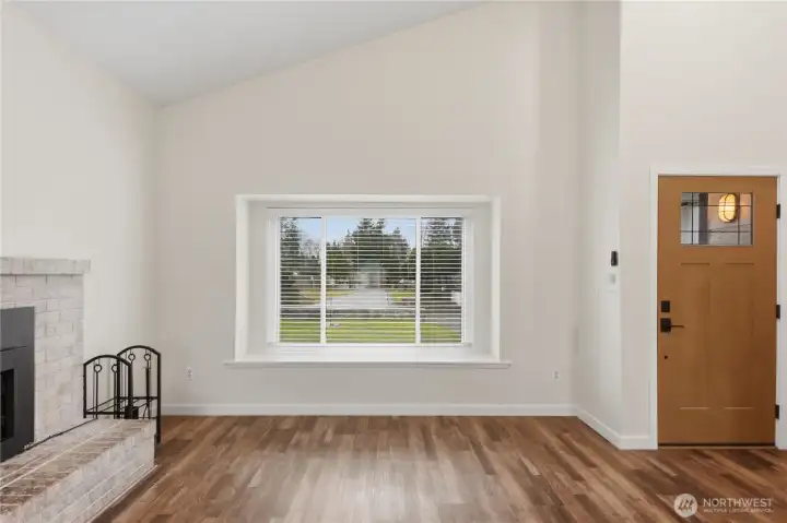 Open and light-filled living room with a wood burning fireplace insert, creating a warm welcome upon entry.