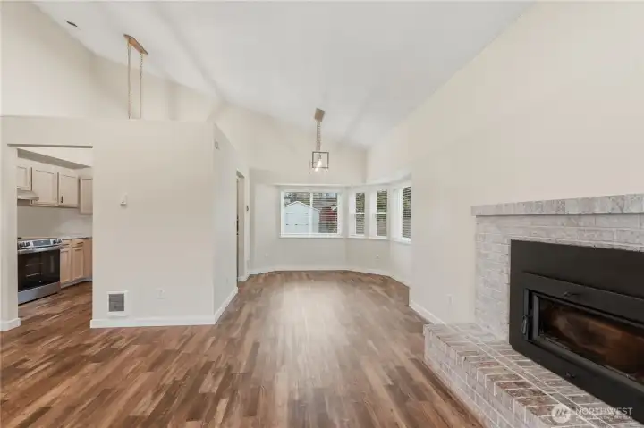 Soaring vaulted ceilings create an airy light filled atmosphere and seamlessly connect the living, dining, and kitchen area.