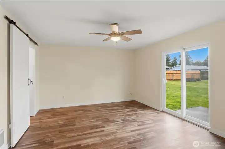 Family Room accented with a Sliding White Barn Door. Glass Slider leads to the fenced back yard & patio.