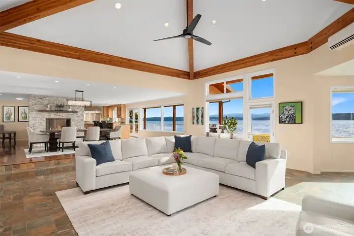 The open-concept living area is designed for effortless entertaining, featuring soaring beamed and vaulted ceilings that enhance the home's spacious, light-filled atmosphere.