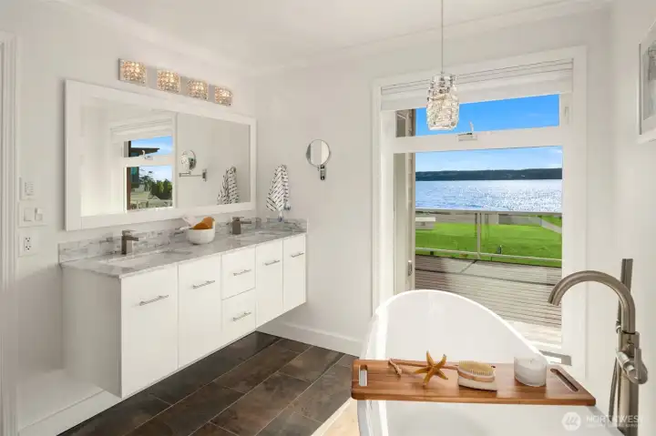 The stunning five-piece primary bath offers a true spa-like retreat, where you can relax in the vessel soaking tub while enjoying breathtaking water views and the soothing sounds of the sea.