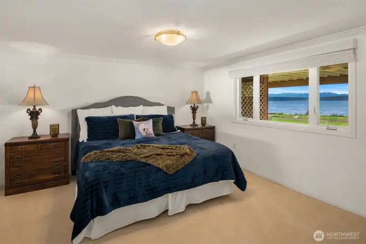 This lower-level bedroom offers a peaceful retreat where you can fall asleep to the soothing sound of waves lapping along the shoreline.