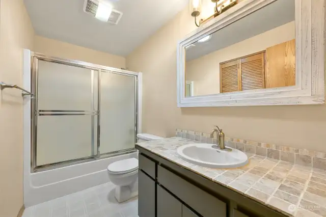 Main bathroom with tub/shower. Solar tube provides natural light.